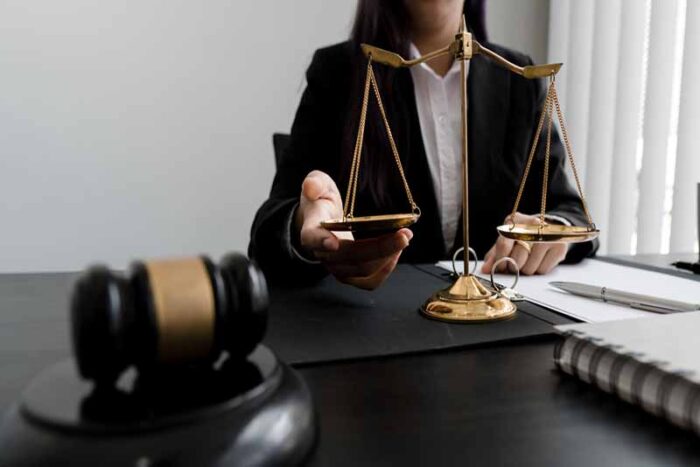 female lawyer working with papers and wooden gavel on table in courtroom.